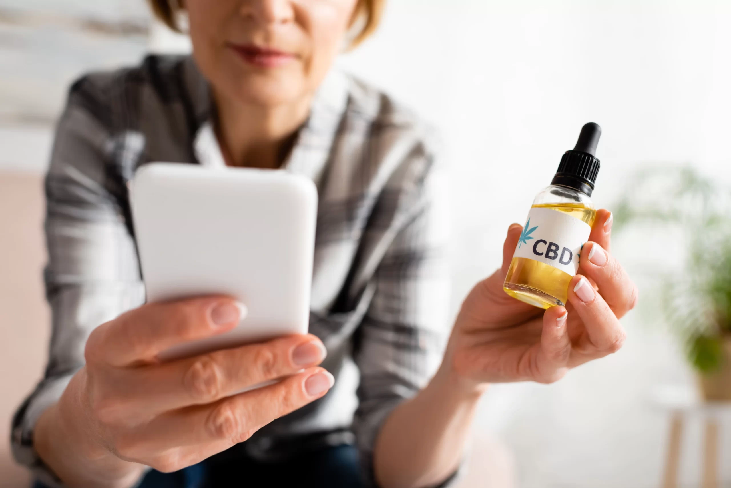 women holding bottle of cbd